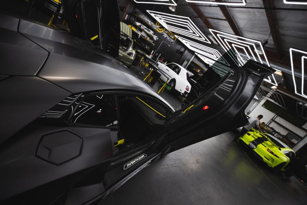 Sleek luxury cars displayed in a futuristic, well-lit garage showcasing innovative automotive design.