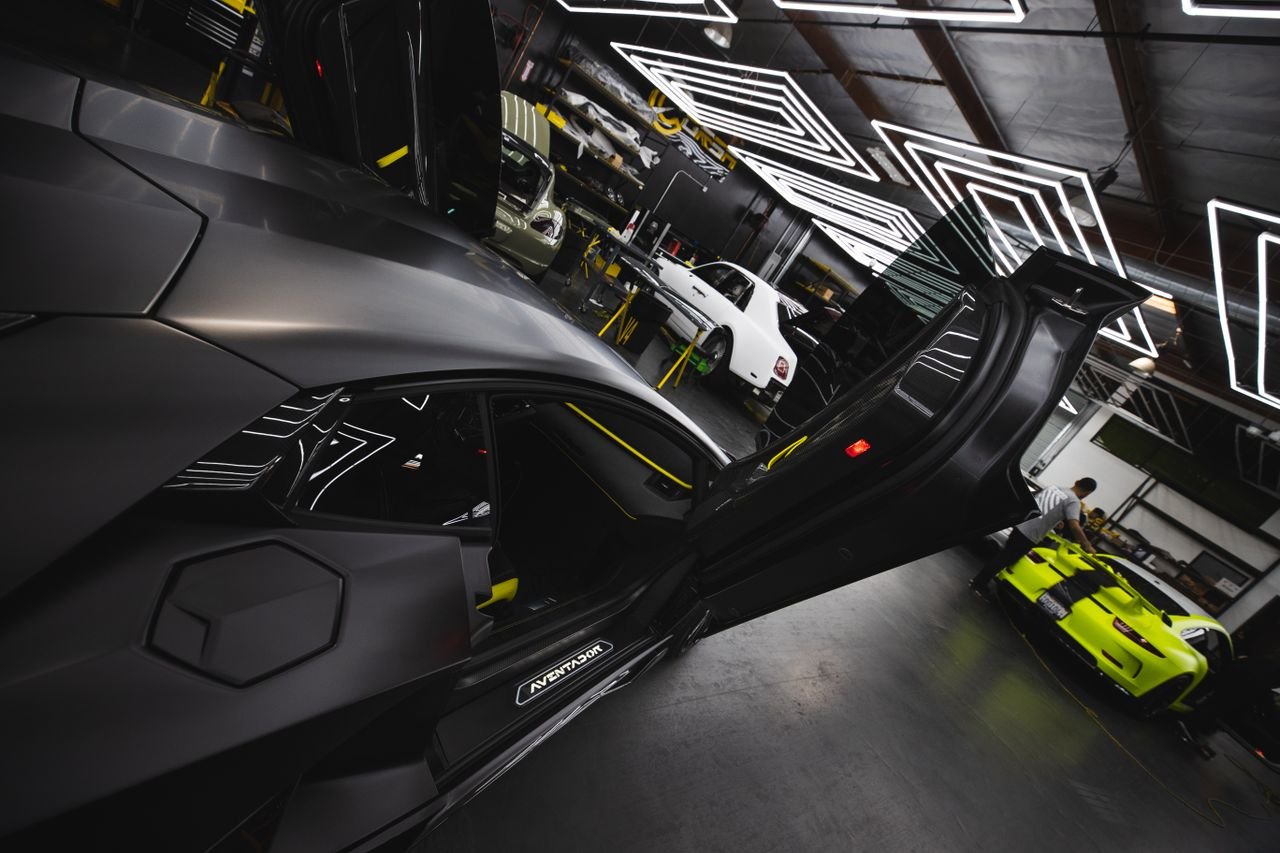 Sleek luxury cars displayed in a futuristic, well-lit garage showcasing innovative automotive design.